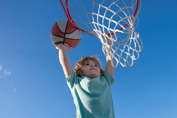 Basketball Slam Dunks of sporty kids basketball player. Close up image of basketball excited kid...