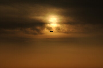 sunset in the sky with an airplane
