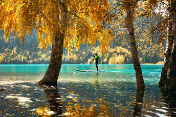 Man on stand up paddle board at mountain lake