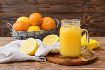Naklejka na ściany i meble Mason jar of orange juice on wooden background