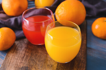 Glasses of orange and grapefruit juice on dark wooden background