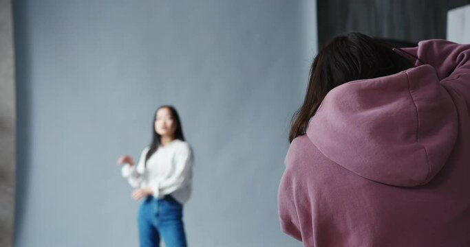 Woman photographer with the professional camera shooting asian korean model