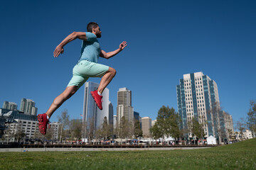 Fototapeta na wymiar Athlete runner feet running in city park. Jogging concept at outdoors. Man running for exercise on City background.