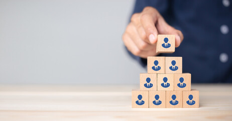 Concept of human resource management and recruitment business Hand put wood cube block on top pyramid To business success concept.