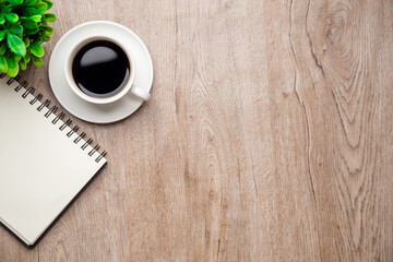 Flat lay, top view office table desk. Workspace with, laptop,office supplies, pencil, green leaf, and coffee cup on wood background.