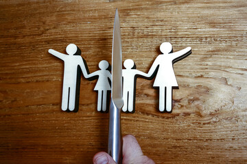 knife divides the whole family. divorce idea. wooden figure. wood background.