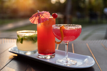 variety of cocktails at sunset light with green leaves background 