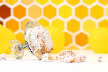 A broken cake lying on an overturned stand. Yellow background with a decor in the form of a...