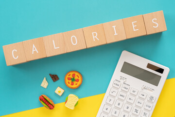 カロリー｜「CALORIES」と書かれた積み木と食べ物のオブジェ
