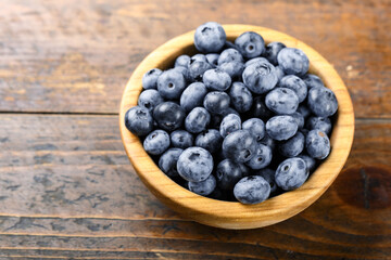 Fresh blueberries in a wooden bowl. Healthy and dietary food concept.