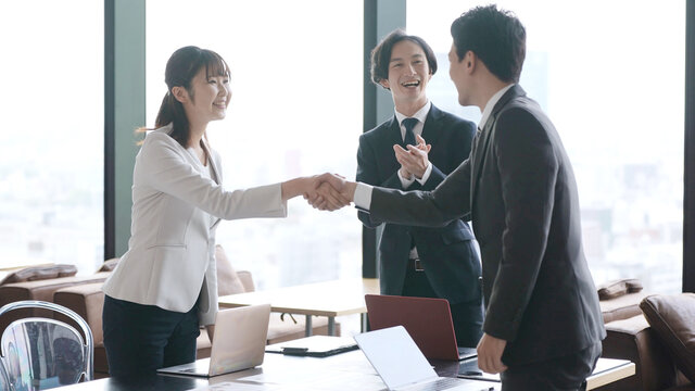 オフィスで握手をするビジネスグループ