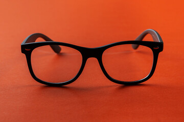Eyeglasses on orange background, myopia or presbyopia.  Eyesight correction.