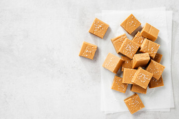 Fresh homemade peanut butter fudge or caramel fudge on light gray background. top view