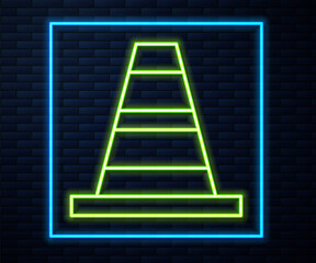 Glowing neon line Traffic cone icon isolated on brick wall background. Vector