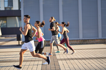 Obraz premium Men and women in sports clothing jogging outdoors