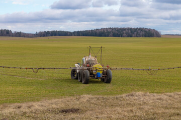 Fototapeta premium Street lighting. special machine on wheels for gentle spraying of crops in the field. Filled with fertilizer for plants.