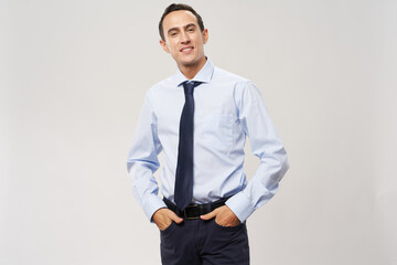 business man in a classic suit on a light background holds his hand in his pocket