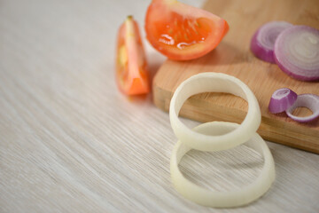 Close-up of onions, tomatos on a chopping board