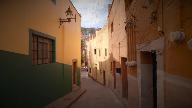 Descending from a narrow street with colorful houses in Guanajuato, Mexico. 4k