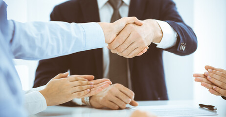 Fototapeta na wymiar Business people or lawyers shaking hands finishing up a meeting, close-up. Negotiation and handshake concepts