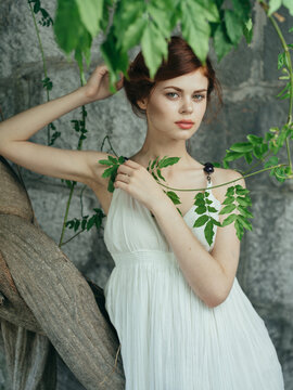 Woman in white dress and green leaves luxury nature model