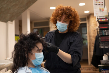 Hairdresser holding with glove hair while dyeing