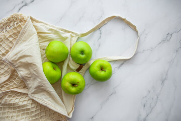 Zero waste shopping concept. Fresh vegetables in eco cotton bags on table in the kitchen. Zero waste shopping and sustainable lifestyle concept. Slow life.