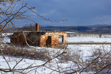 abandoned red brick building, ruined house, on a winter background