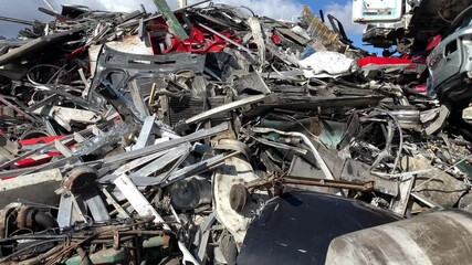 Unusable car parts stacked up for on junkyard. A pile of scrap metal, old car parts on a car dump. Car parts rubbish on recycling plant site. Old Junk Cars On Junkyard.  - Powered by Adobe