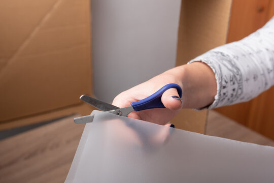 Woman hand cutting with scissors tissue paper and copy space