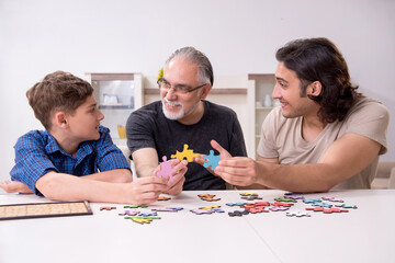 Three generations of family playing jigsaw puzzle game