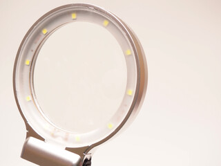 Close up shoot of printed circuit board (PCB) sitting on a white repair stand with magnifier for better examining small parts. Shoot on a white isolated background