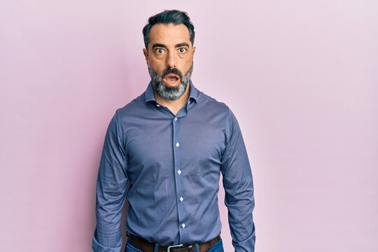 Middle age man with beard and grey hair wearing business clothes afraid and shocked with surprise expression, fear and excited face.