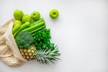 Zero waste shopping concept. Fresh vegetables in eco cotton bags on table in the kitchen. Cotton shopping bag full of vegetables and fruits. Ingredients for healthy food. Eco friendly shopping.