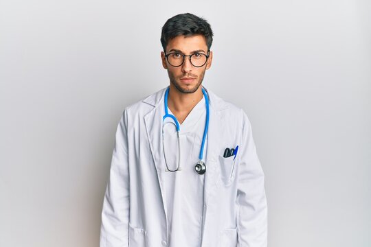 Young handsome man wearing doctor uniform and stethoscope skeptic and nervous, frowning upset because of problem. negative person.