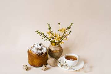Easter composition with kulich and eggs with spring flowers on beige background. Easter holidays breakfast concept.