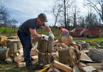 Couple of farmers splitting wood