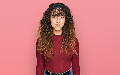 Young hispanic girl wearing casual clothes puffing cheeks with funny face. mouth inflated with air,...