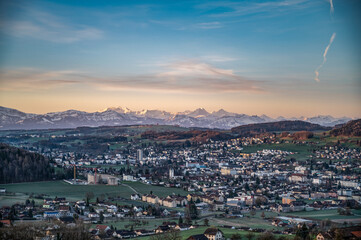 Naklejka premium view of a town and the alps in beautiful sunrise 
