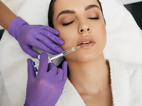 Lips filler injection for beautiful woman lip augmentation with hyaluronic acid at a beauty salon