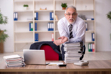 Aged male employee unhappy with excessive work in the office