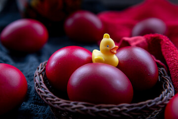 close up of red dyed Easter Eggs in a wicker basket.