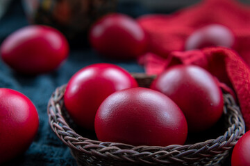 close up of red dyed Easter Eggs in a wicker basket.
