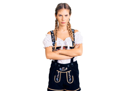Beautiful caucasian woman with blonde hair wearing octoberfest traditional clothes skeptic and nervous, disapproving expression on face with crossed arms. negative person.