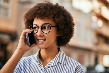 Young hispanic businesswoman smiling happy talking on the smartphone at the city.