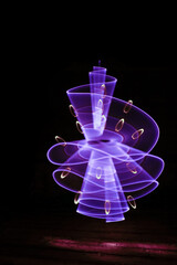 Abstract curved purple shape with a bright saber. Pattern for wallpaper. Made with lightpainting technique.