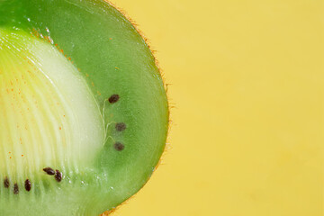 close up green kiwi on yellow background with place for text