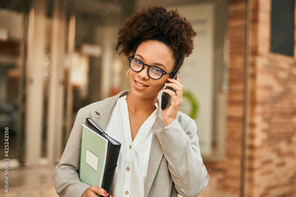 Poster Young african american businesswoman smiling happy talking on the smartphone at the city.