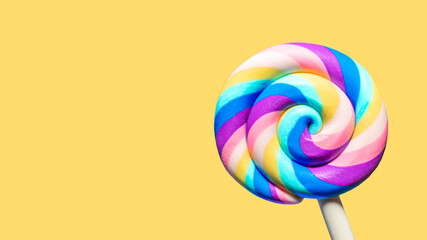 Sweet lollipops on a yellow background with copy space