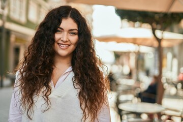 Young hispanic woman smiling happy standing at the city.